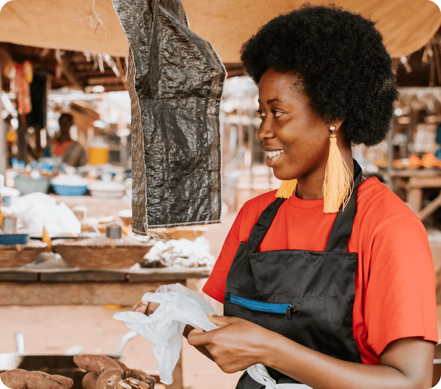 A woman smiling at her customer in the market